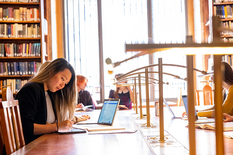 Student writing in library